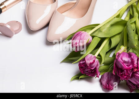 Pink tulips and beige shoes on white background close-up Stock Photo