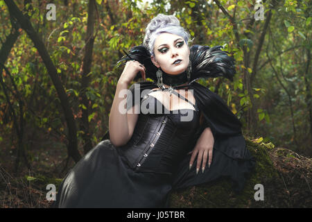 Beautiful woman a witch in the dark forest. Stock Photo