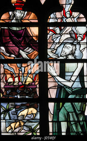 Stained Glass in the Church of Tervuren, Belgium, depicting God reaching His Hand towards His Son Jesus Christ and a lamb burning, symbolizing Agnus D Stock Photo