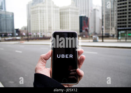 Chicago,IL,USA,Feb-21,2017,Man holding a smartphone with an open Uber app in the city (for editorial use only) Stock Photo