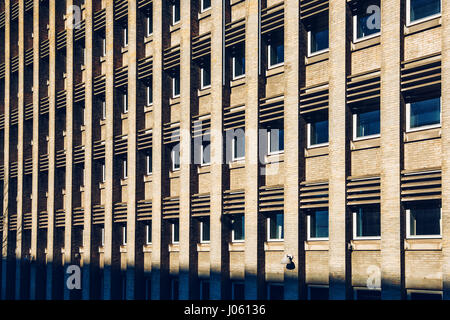 Building facade with repeating pattern of windows and brick columns Stock Photo