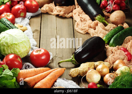 Frame made from fresh vegetables on wooden rustic table. Top view, space for text. Eggplants, cabbage, carrot, tomato, onion and other. Stock Photo
