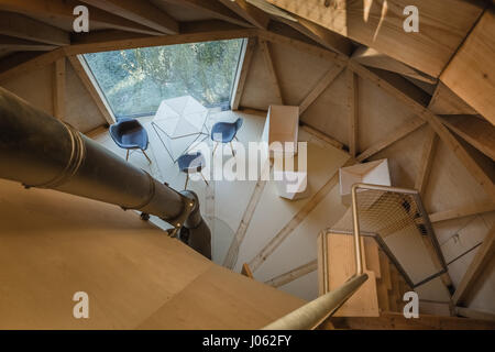 CZECH REPUBLIC: A view from the upper floors. LIKE A house from a children’s fairy tale this quirky home set in a stunning orchard looks just like a giant pear. The series of quirky images show inside the home’s curved interior of the living room complete with cosy wood burner and narrow kitchen and bathroom. One shot even shows a floor length window open towards the outdoors. Exterior shots show the pear-shaped home’s concrete foot that supports its structure and another photo shows a steel footbridge that connects to the ground below. The home also known as the House in the Orchard is built  Stock Photo