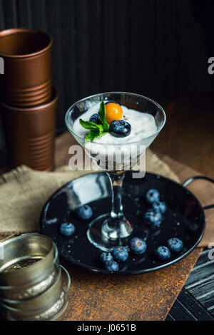 Healthy yogurt with blueberries, strawberries and cereals. Dessert. The restaurant or cafe atmosphere. Vintage Stock Photo