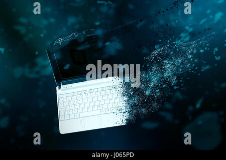 The old laptop is disintegrating in space. Conception of passage of time and obsolete technology Stock Photo