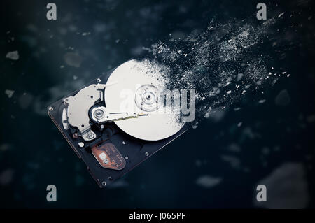 The old hard disk drive is disintegrating in space. Conception of passage of time and obsolete technology Stock Photo
