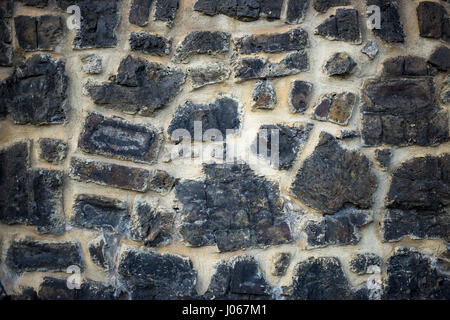 Gray color pattern of decorative uneven cracked real stone wall surface with cement Stock Photo