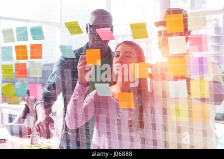 Blue data against business people discussing over adhesive notes Stock Photo