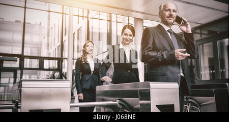 Businesspeople scanning cards at turnstile gate in office Stock Photo