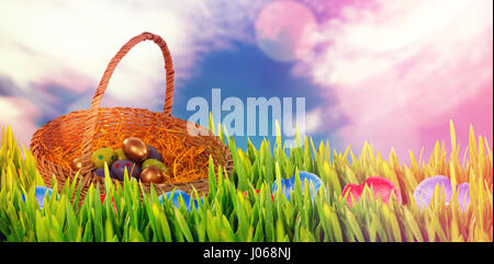 Easter eggs in paper nest basket against glowing background Stock Photo