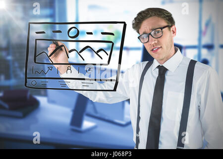 Geeky businessman writing with marker against blurry picture of computer on desk Stock Photo
