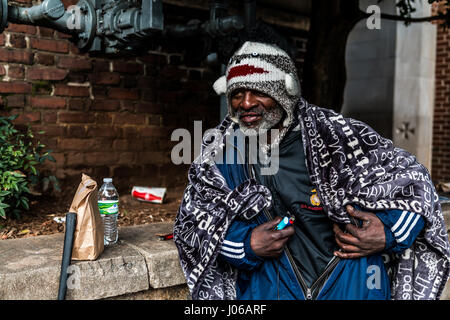 Atlanta.  HEART-WRENCHING pictures show military veterans struggling to get by living on the streets after serving their country. The touching photos show the homeless veterans of wars including Iraq, Afghanistan and even Vietnam begging on the streets, accepting donations from strangers and tucking into a welcome meal. Some cling to the past and still wear their old military clothing while others display signs indication their service history to passers-by. The powerful shots were taken in Washington DC, northern Florida and Atlanta by American photographer Jeff Hagerman (35) from Atlanta, Ge Stock Photo