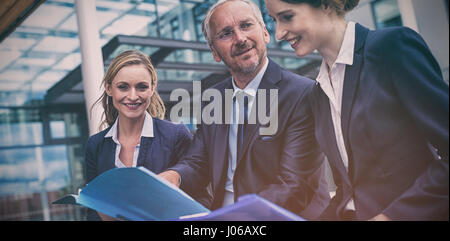 Businesspeople discussing over documents in office premises Stock Photo
