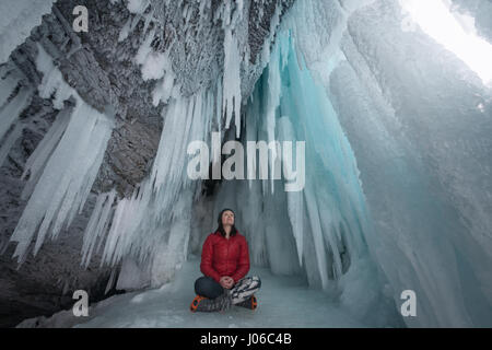 ALBERTA, CANADA: STUNNING images showing women having fun inside sparkling frozen Canadian waterfalls have been revealed by one British expat who lives there. The series of shots show the women sitting directly below giant icicles and walking through what looks like a maze of icicles that touch the frozen ground. Other shots show people taking pictures and admiring the glistening ice formations. One super fun shot shows a woman sliding down an icy slope on her bottom with her arms out wide. The spectacular photographs were taken at Icefields Parkway, near Banff in Alberta, Canada by photograph Stock Photo