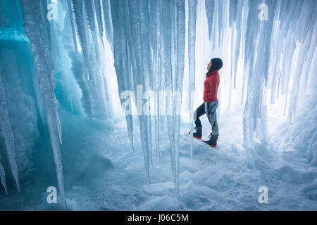 ALBERTA, CANADA: STUNNING images showing women having fun inside sparkling frozen Canadian waterfalls have been revealed by one British expat who lives there. The series of shots show the women sitting directly below giant icicles and walking through what looks like a maze of icicles that touch the frozen ground. Other shots show people taking pictures and admiring the glistening ice formations. One super fun shot shows a woman sliding down an icy slope on her bottom with her arms out wide. The spectacular photographs were taken at Icefields Parkway, near Banff in Alberta, Canada by photograph Stock Photo