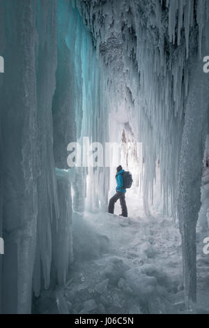 ALBERTA, CANADA: STUNNING images showing women having fun inside sparkling frozen Canadian waterfalls have been revealed by one British expat who lives there. The series of shots show the women sitting directly below giant icicles and walking through what looks like a maze of icicles that touch the frozen ground. Other shots show people taking pictures and admiring the glistening ice formations. One super fun shot shows a woman sliding down an icy slope on her bottom with her arms out wide. The spectacular photographs were taken at Icefields Parkway, near Banff in Alberta, Canada by photograph Stock Photo