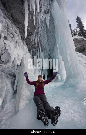 ALBERTA, CANADA: STUNNING images showing women having fun inside sparkling frozen Canadian waterfalls have been revealed by one British expat who lives there. The series of shots show the women sitting directly below giant icicles and walking through what looks like a maze of icicles that touch the frozen ground. Other shots show people taking pictures and admiring the glistening ice formations. One super fun shot shows a woman sliding down an icy slope on her bottom with her arms out wide. The spectacular photographs were taken at Icefields Parkway, near Banff in Alberta, Canada by photograph Stock Photo