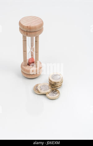 Egg timer on plain background - as metaphor for concept of 'time is money', the value of time, time management. Stock Photo