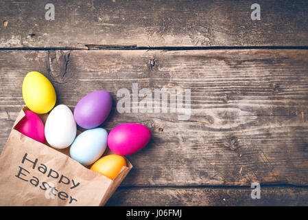 Easter bunny in a paper bag on old boards Stock Photo