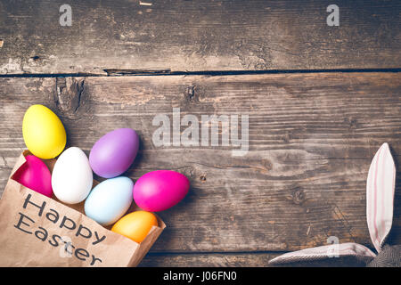 Easter bunny in a paper bag on old boards Stock Photo