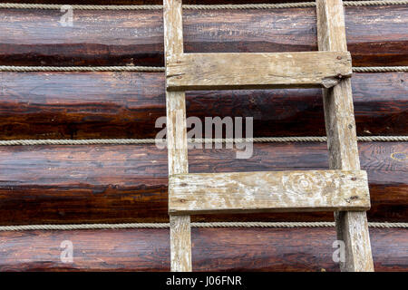 Neutral background wall of round logs of ropes and a lading textured staircase Stock Photo
