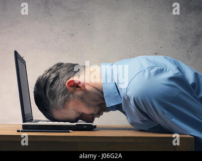 Handsome business man sleeping on a laptop Stock Photo