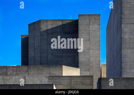 Parts of the brutalist architecture facade of the National Theatre in London against a blue sky Stock Photo