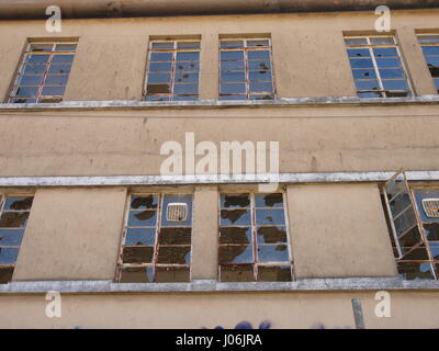 Broken windows on derelict building Stock Photo
