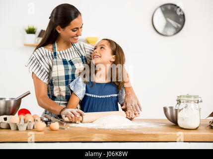 Shot of a mother and daughter having fun in the kitchen and learning to make a cake Stock Photo