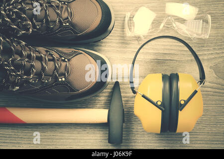 Working tools from above retro style. Protective working wear close-up on wooden backdrop. Retro work tools background. Stock Photo