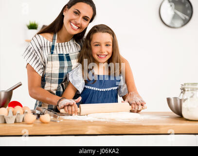 Shot of a mother and daughter having fun in the kitchen and learning to make a cake Stock Photo