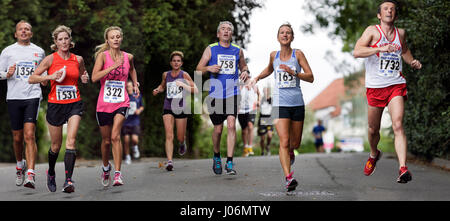 Photomontage of Male and female athletes wearing running sports clothing pictured running in a half marathon road race in Chippenham, England,UK Stock Photo