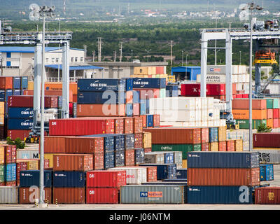 Horizontal view of brightly coloured containers stacked high at a port in Vietnam. Stock Photo