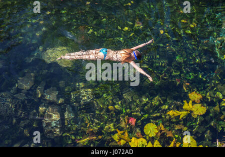 woman swimming in a cenote waterhole in Mexico Stock Photo