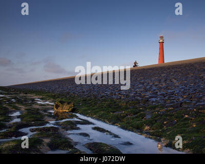 lighthouse  and dyke with bycycle Stock Photo