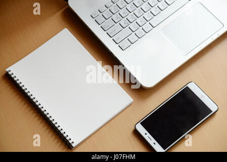 computer notebook with smartphone and notebook on wooden background Stock Photo