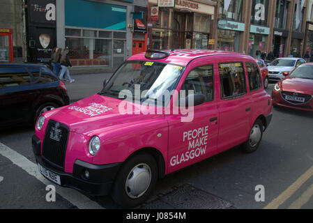 People Make Glasgow  pink taxi cab on the street in Scotland Stock Photo