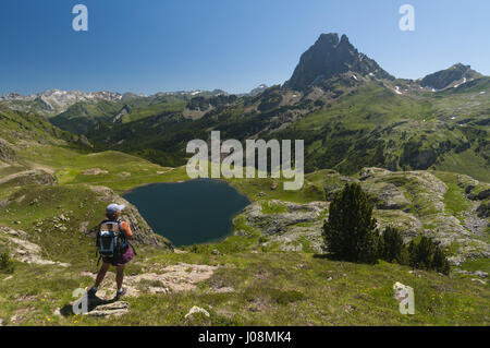 France, Pyrenees, Lacs d'Ayous lakes, Lake Roumassot with Pic du Midi d'Ossau and hiker Stock Photo