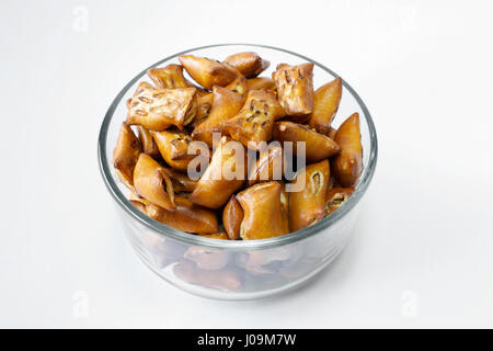 A portion of unsalted peanut butter pretzels in glass bowl on white background Stock Photo