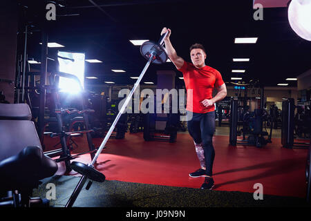 Athletic male athlete doing exercises with a barbell in the gym Stock Photo