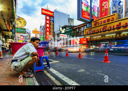 BANGKOK, THAILAND - FEBRUARY 03: This is one of the main roads in Chinatown Bangkok with a street vendor waiting and watching the ongoing traffic on F Stock Photo