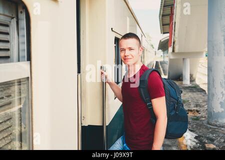 Young man on holiday traveling by historical train. Stock Photo