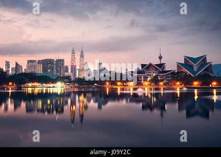 Kuala Lumpur at the sunrise and reflection of the city skyline in the lake, Malaysia Stock Photo