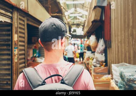 Young traveler with backpack in street market in Chinatown - Kuala Lumpur, Malaysia Stock Photo