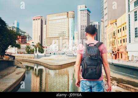 Young tourist watching on modern city with high-rise and old traditional buildings and Masjid Jamek Mosque in Kuala Lumpur Stock Photo