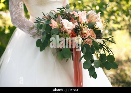 Wedding gentle disheveled bouquet of peach shades with pink ribbon. Horizontal photo, side view Stock Photo