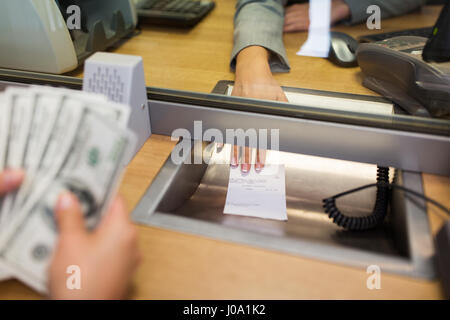 bank clerk giving receipt to customer with money Stock Photo