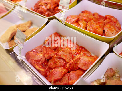 marinated meat in bowls at grocery stall Stock Photo