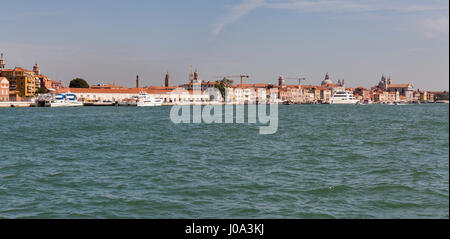 VENICE, ITALY - SEPTEMBER 23, 2016: Luxury yachts moored along embankment in Venice lagoon with cityscape. Venice is situated across 117 islands that  Stock Photo