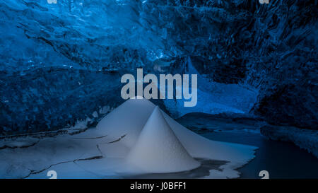 VATNAJOKUL, ICELAND: Snow pillar inside glacier. SUNLIGHT striking the inside of an ice cave transformed a normally blue frozen world into what looks like a golden glacier. Other images taken from inside the frozen formation range from the explorers, which include British tourists, keeping warm with a fire deep within the underground walls and exploring mighty snow pillars. Mountain guide Einar Runar Sigurdsson (47) from Oraefi, Iceland took the shots at the Vatnajokull Crystal Ice Cave, 50-miles from the nearest town Hofn, in the southeast of Iceland. Stock Photo